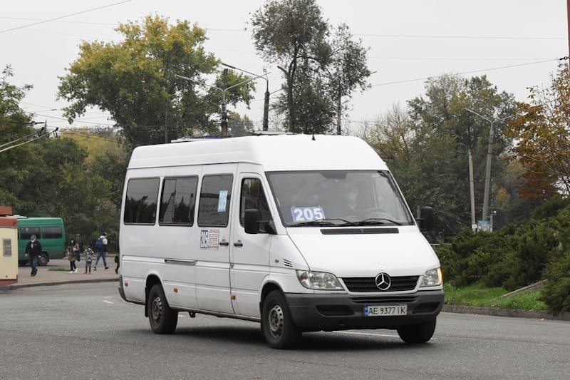 Білий мікроавтобус Mercedes-Benz Sprinter з номером маршруту 205 на лобовому склі їде дорогою