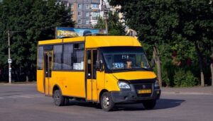 Жовта маршрутка з номером 210 на лобовому склі їде дорогою
