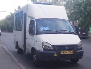 Біла маршрутка Газель з номером 230 на лобовому склі стоїть на узбіччі дороги