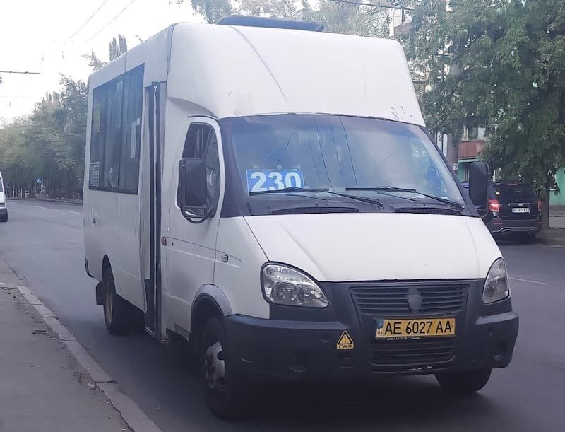 Біла маршрутка Газель з номером 230 на лобовому склі стоїть на узбіччі дороги