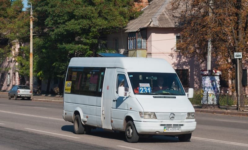 Біла маршрутка Mercedes-Benz Sprinter з номером 231 на лобовому склі їде дорогою