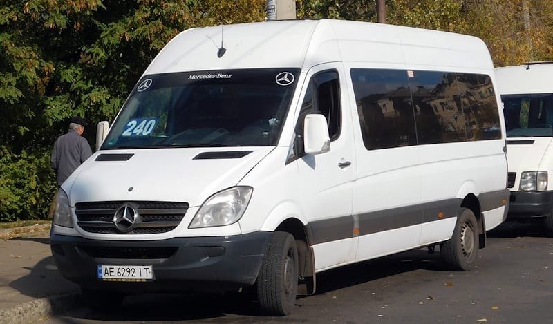 Біла маршрутка Mercedes-Benz з номером 240 на лобовому склі припаркована на вулиці