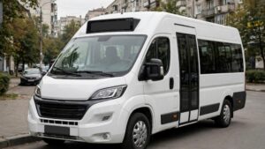 Біла маршрутка на вулиці міста біля житлових будинків