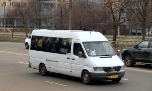 Біла маршрутка Mercedes-Benz Sprinter з номером 223 на лобовому склі рухається дорогою