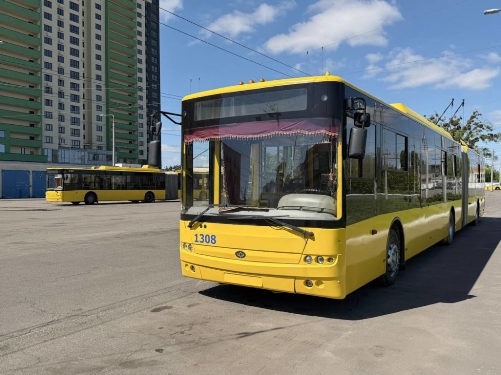 Жовтий тролейбус на стоянці біля будівлі